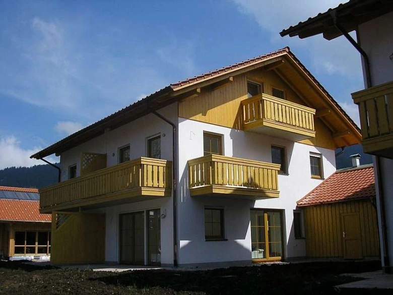 Moderní dům s dřevěnými balkony na fasádě.