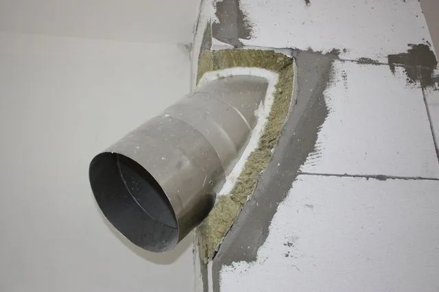 Instalace vložky do komína s izolací ve zdi.