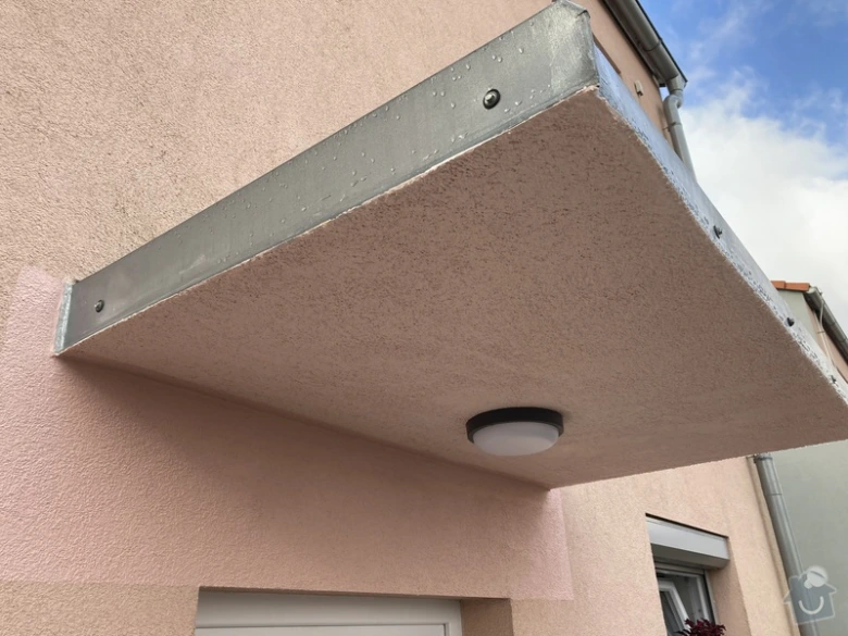 Nově nainstalovaná předsíňka nad dveřmi na fasádě domu.