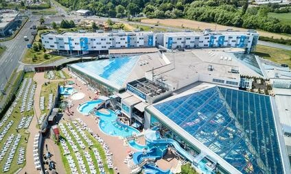 Pohled na velký bazénový komplex s vnitřním akvaparkem.