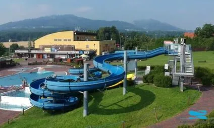 Modré vodní skluzavky vedle bazénu v koupališti.