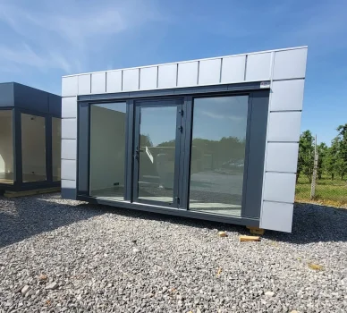 Moderní kontejnerový dům s velkými okny na štítové straně.