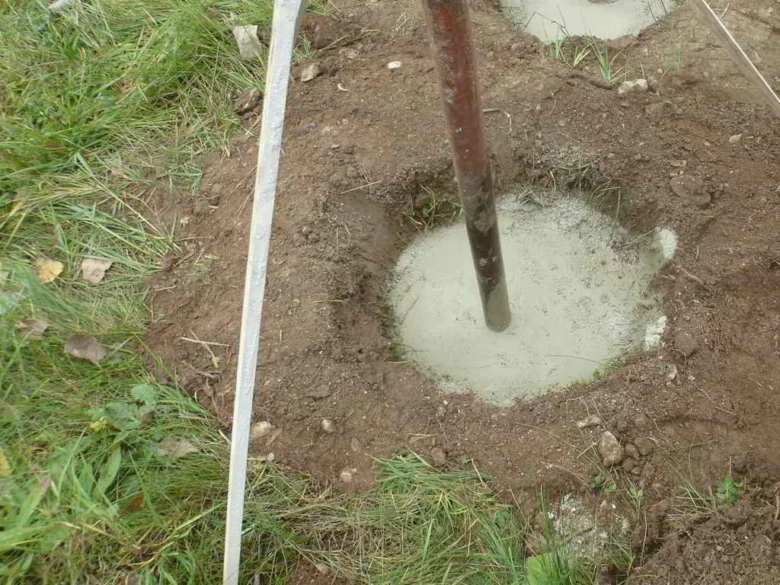 Čerstvě nalitý beton do otvoru pro sloup v zemi.