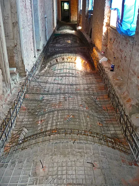 Helikální výztužná síť položená na podlaze před betonováním.