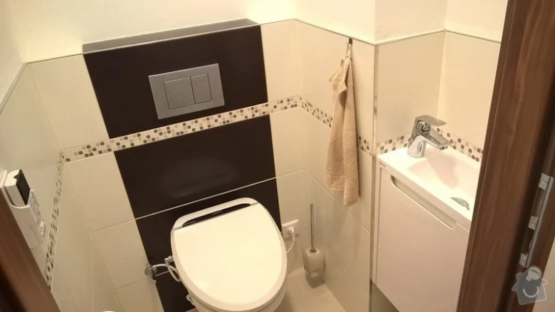 Moderní koupelna s tmavými panely na stěně záchodu.