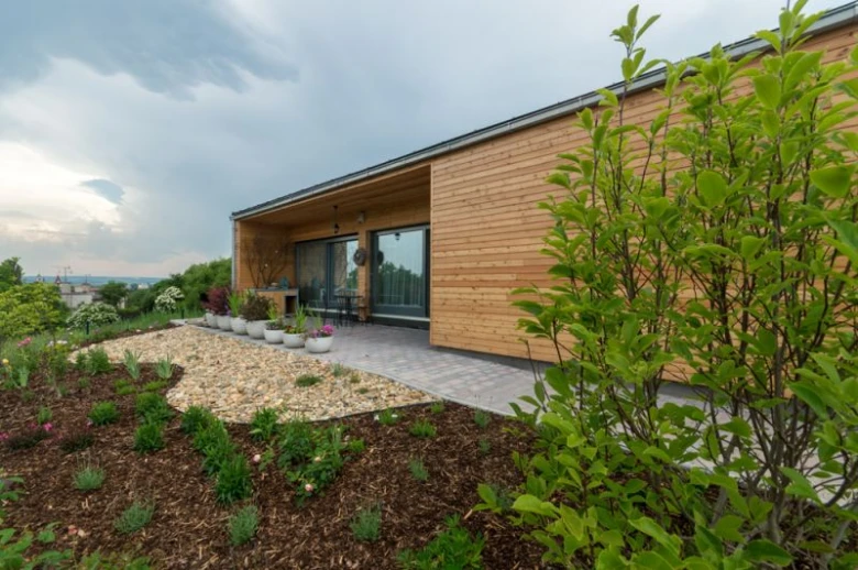 Moderní dřevěný bungalov s zahradou a skleněnými dveřmi.