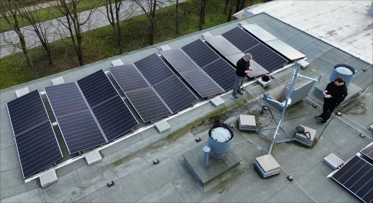 Fotografie fotovoltaických panelů na střeše novostavby.