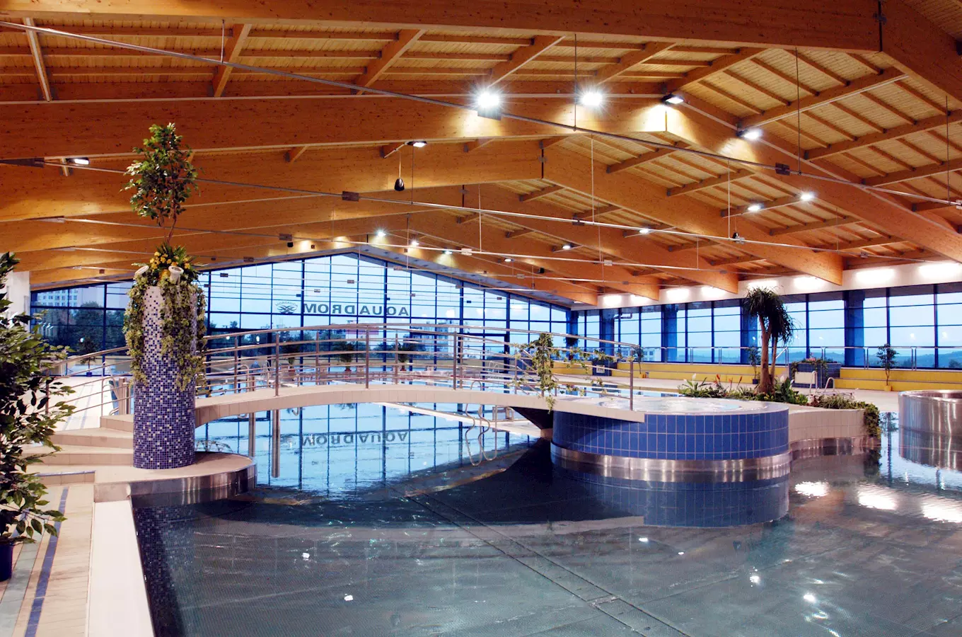 Vnitřní bazén a aquapark v Mostě s dřevěným stropem.