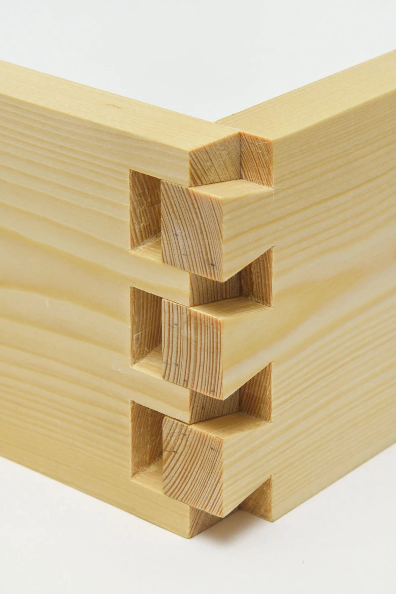 Detail dřevěného spoje s hrdlem v koutu stavební konstrukce.