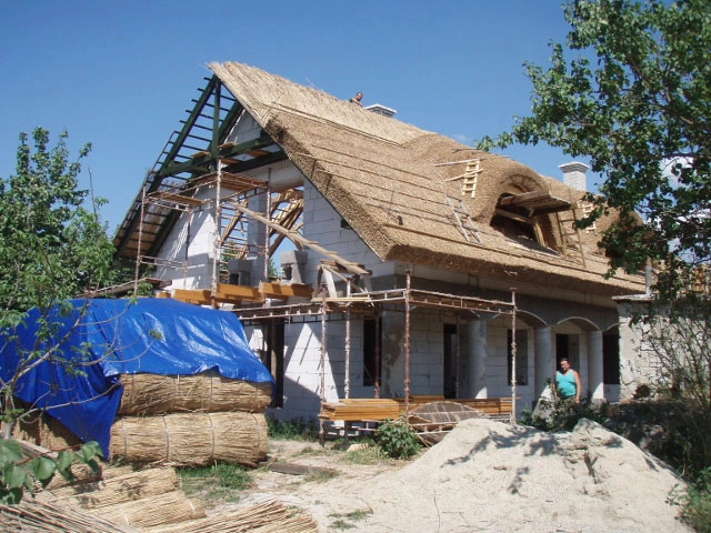 Stavba doškové střechy na domě s materiálem pro krytinu.