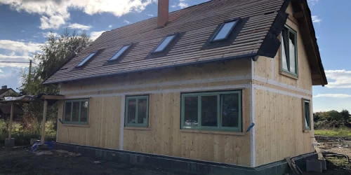 Dřevostavba v stavbě s viditelnou konstrukcí a okny.