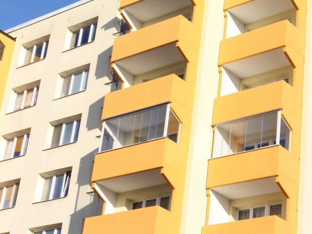 Zasklené balkony v bytovém domě po dokončení zasklívání.