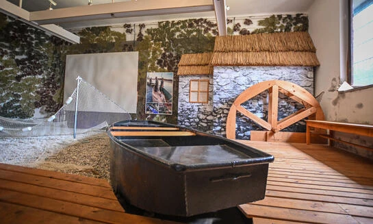 Vnitřní expozice s lodí v bazénu u historické vesnice