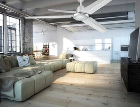 Bílý stropní ventilátor v prostorném obývacím pokoji s velkými okny.
