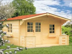 Dřevěná chata s podkrovím a malými balkony na trávníku.