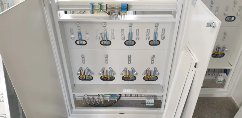 Vnitřní část elektrického rozvaděče s uspořenými komponenty.