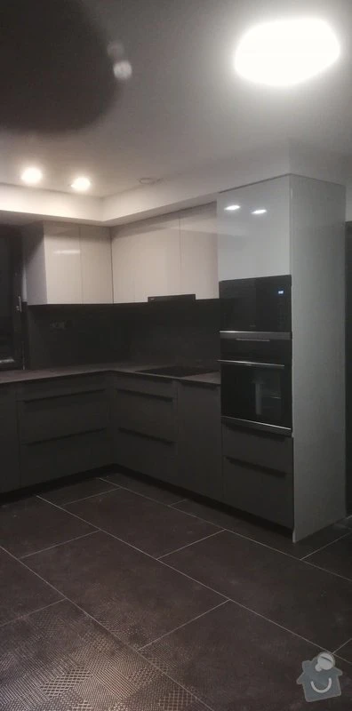 Moderní kuchyně na míru s tmavými skříněmi a vestavnou technikou.