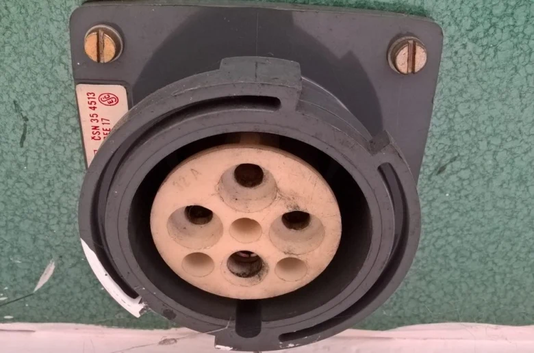 Průmyslová elektrická zásuvka s viditelnými kontakty pro zapojení.
