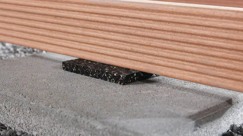 Detailní řez dřevěnou terasou s izolací a betonovou základnou.