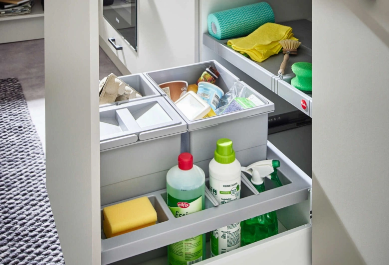Organizace kuchyňské skříňky s úložnými boxy a čistící prostředky.