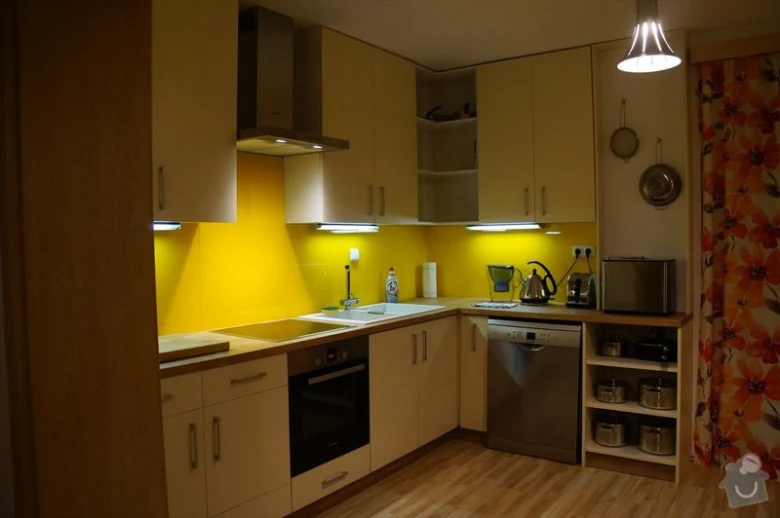 Moderní kuchyňská linka po rekonstrukci s žlutou stěnou.