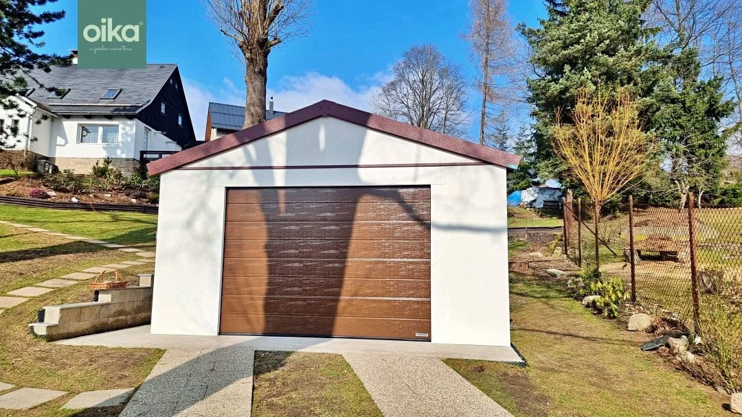 Moderní garáž s hnědými dveřmi pro auto na trávníku.