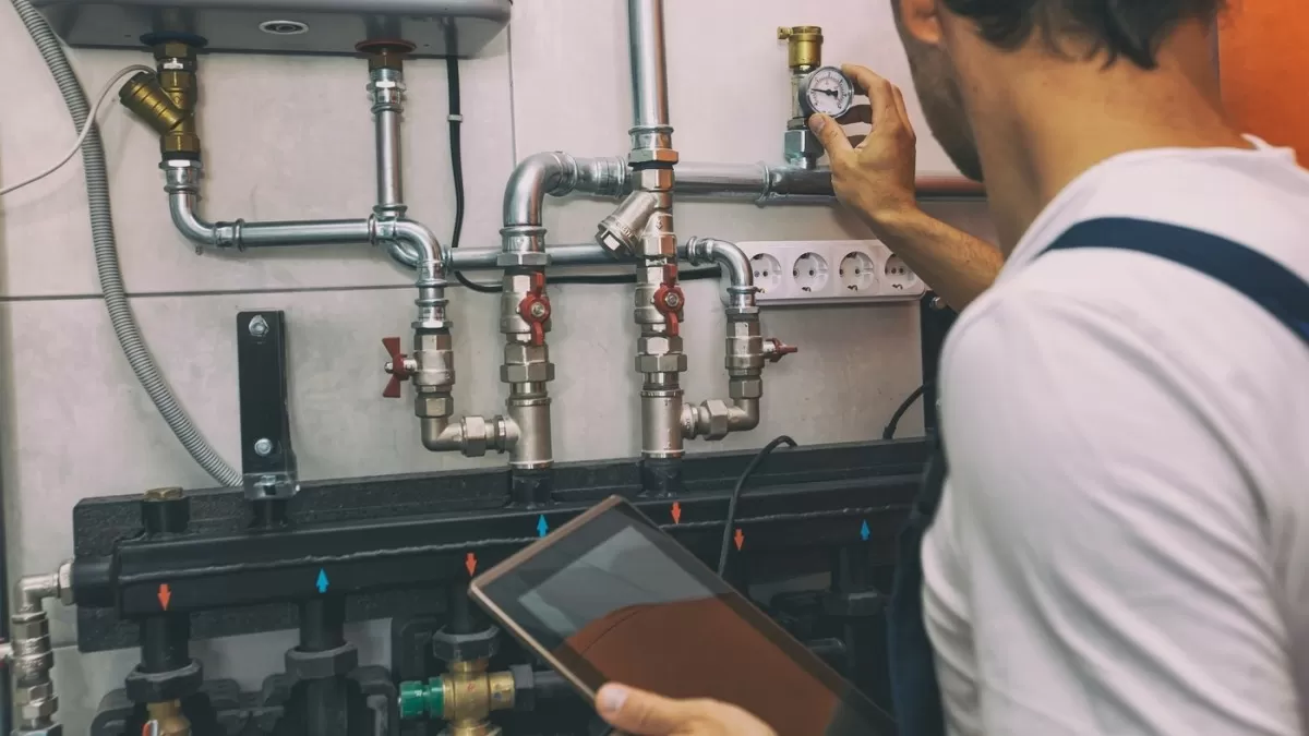 Technik kontroluje tlak v systému tepelného čerpadla nebo solárního ohřevu.