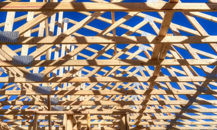 Detail dřevěného trámoví střechy s viditelnými spojovacími prvky.