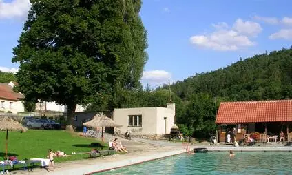 Venkovní bazén v Horažďovicích s okolním trávníkem a stromy.