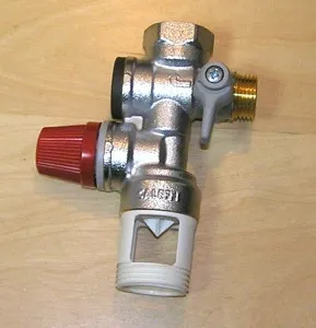 Kovový ventil s červenými knoflíky pro plynové topení.