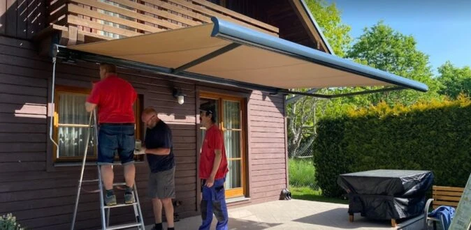 Instalace markýzy na balkon s pomocí tří pracovníků.