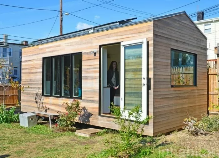 Modulový dřevěný dům s fotovoltaickými panely na střeše.